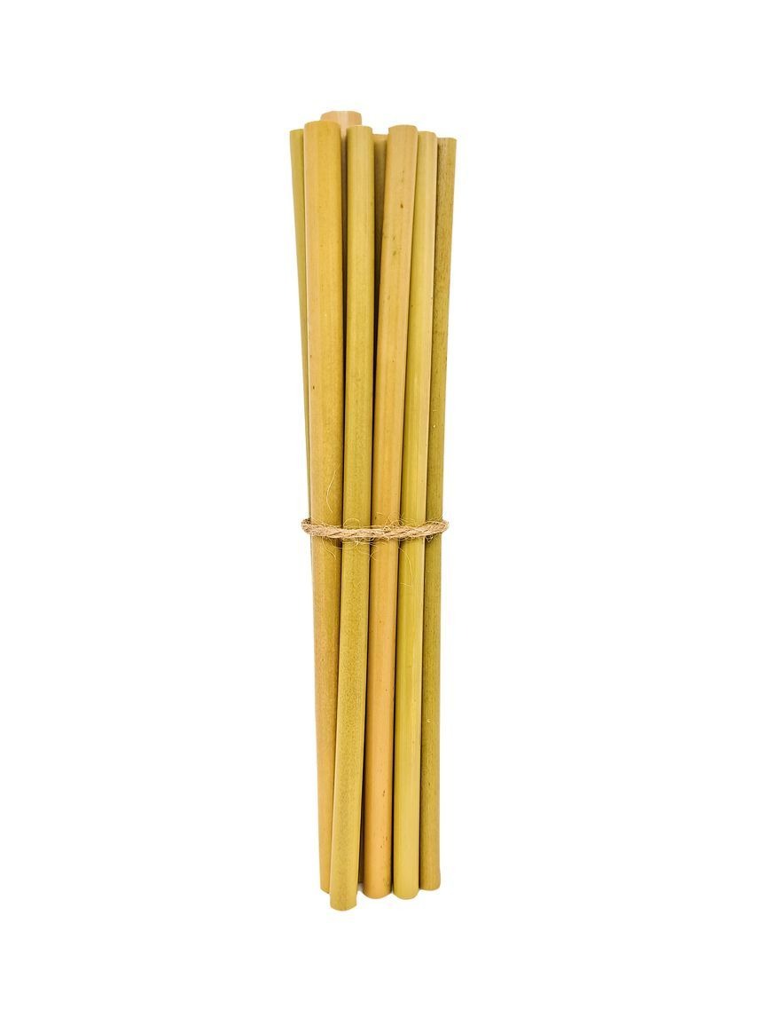 Lot de 6 grandes pailles en bambou naturel posées à côté d’un verre de smoothie sur une table en bois.

