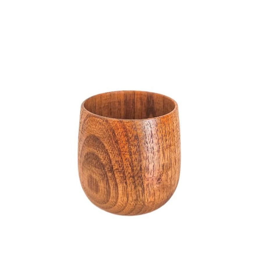 Mug en bois naturel de jujubier posé sur une table, rempli d’une boisson chaude.

